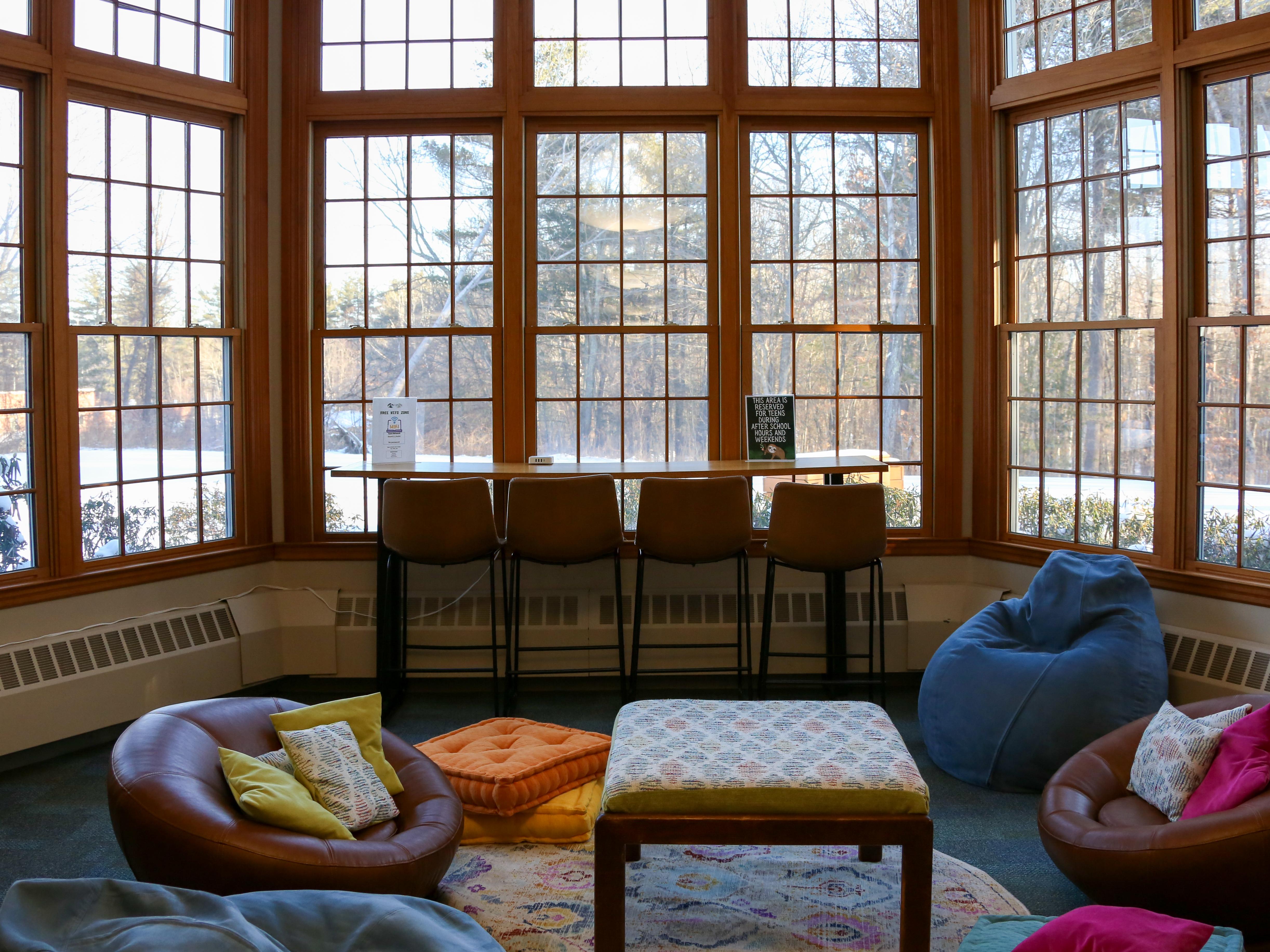 The teen space with comfortable chairs, and a high table with stools. 