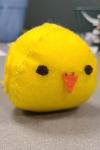 Photo of softie chick figure, yellow, resting on a desk surface